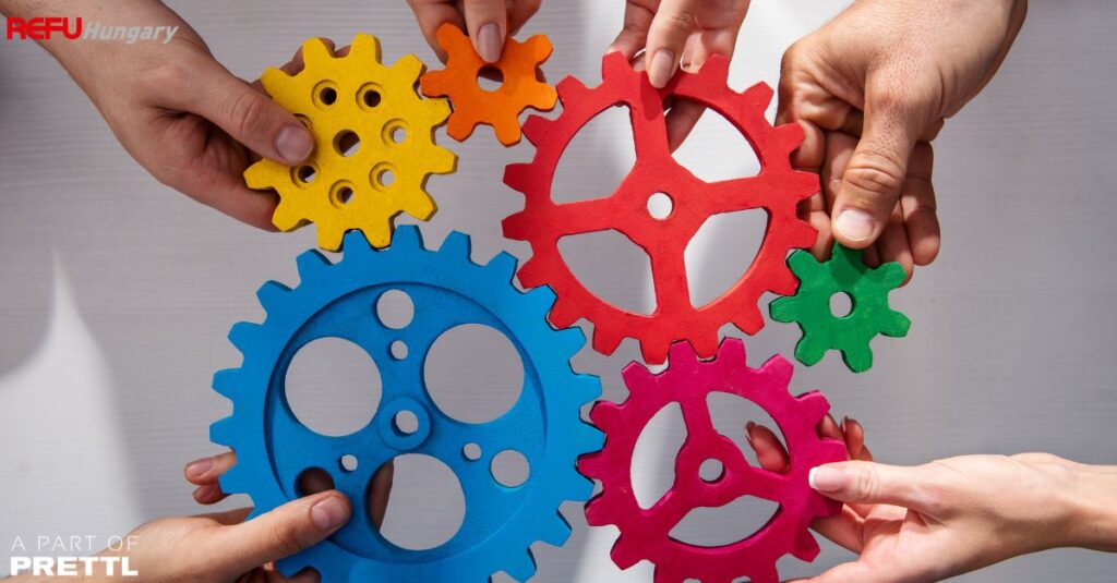 Hände mit Zahnrädern – Symbol für Zusammenarbeit bei der Prototypenfertigung Kleinserie